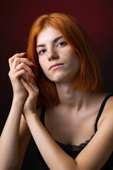 Fototapeta premium Cute red-haired girl, studio portrait on a black background.