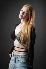 Naklejka premium Portrait of a blonde woman with freckles in a sexy top and denim shorts in a studio.