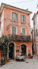 Obraz premium Peach building cafe, cobblestone street, Italian village, outdoor seating
