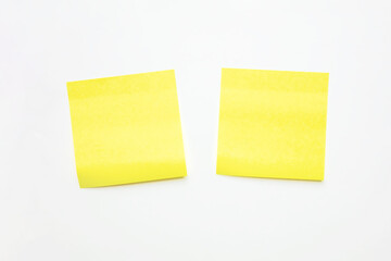 Two Bright Yellow Sticky Notes Are Placed on Smooth White Background. Offer a Clear and Vibrant Option for Jotting Down Reminders or Organizing Thoughts.