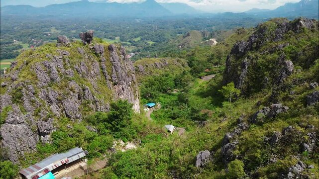 aerial footage of the cityscape behind the rock cliffs in Toraja Indonesia