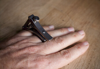 metal capo clapping the fingers of a hand 