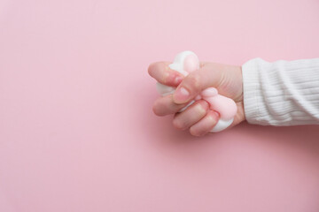 Taba paw pink and white colorful anti-stress toys squirt on baby's hand.