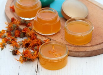 Organic calendula cream for healthy skin. Homemade preparation of organic medicinal ointment from marigold flower heads.  It helps post-surgery to better heal scars.