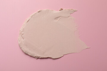 Cream on pink background, top view. Sample of cosmetic product