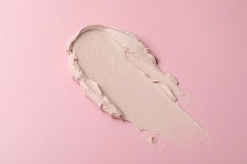 Cream on pink background, above view. Sample of cosmetic product