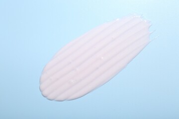 Cream sample on light blue background, top view