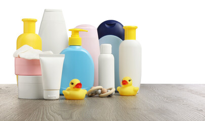 Baby cosmetic products and bath accessories on wooden table against white background