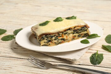 Piece of tasty spinach lasagna on wooden table, closeup