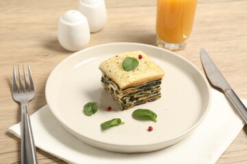 Piece of tasty spinach lasagna served on wooden table, closeup