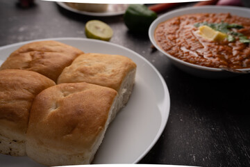 Mumbai Style Pav or paav bhaji is a fast food dish from India, consists of a thick vegetable curry served with a soft bread roll, served in a plate