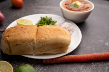 Mumbai Style Pav or paav bhaji is a fast food dish from India, consists of a thick vegetable curry served with a soft bread roll, served in a plate