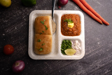Mumbai Style Pav or paav bhaji is a fast food dish from India, consists of a thick vegetable curry served with a soft bread roll, served in a plate