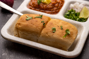 Mumbai Style Pav or paav bhaji is a fast food dish from India, consists of a thick vegetable curry served with a soft bread roll, served in a plate
