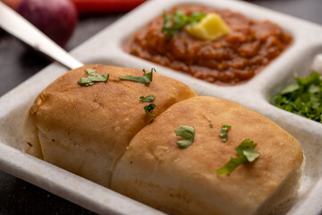 Mumbai Style Pav or paav bhaji is a fast food dish from India, consists of a thick vegetable curry served with a soft bread roll, served in a plate