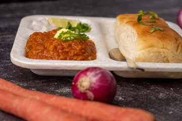 Mumbai Style Pav or paav bhaji is a fast food dish from India, consists of a thick vegetable curry served with a soft bread roll, served in a plate