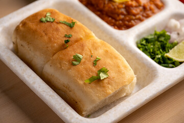 Mumbai Style Pav or paav bhaji is a fast food dish from India, consists of a thick vegetable curry served with a soft bread roll, served in a plate