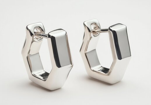 Sleek hexagonal silver earrings with polished finish on white background