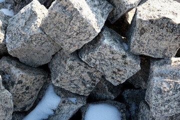 Textured stones pile resting under a blanket of soft white snow