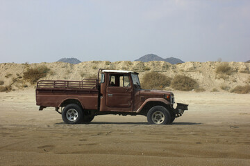 An old vintage car in the desert sands