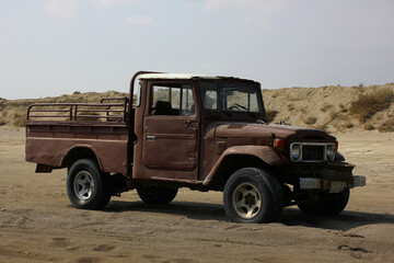 An old vintage car in the desert sands