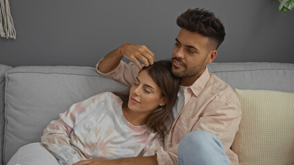 Fototapeta premium Couple relaxing in comfortable living room, woman leaning on man, home interior with cozy ambiance, showing love and togetherness