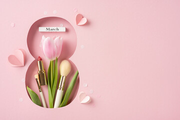 A creative flat lay design with tulips, lipstick, brush, and pink decorations symbolizing femininity and celebration