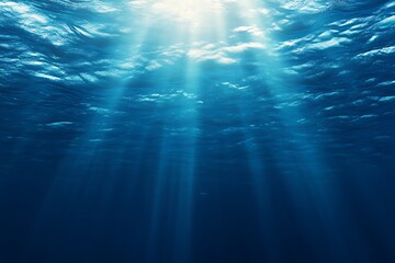Fototapeta premium Sunlight beams through the deep blue ocean depths.
