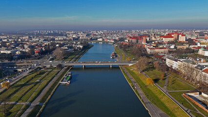 Fototapeta premium Aerial view of Krakow, Poland, Vistula River, bridge, and Wawel Castle in the background.