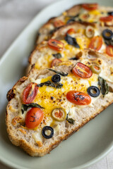 open sandwiches sourdough bread toast for breakfast or brunch with cheese tomato olives.