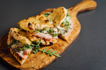 Close up of Pizza-Sandwich with Mortadella and Roasted Eggplant – A gourmet Italian creation featuring mortadella sausage, roasted eggplant, parmesan cheese, mozzarella, truffle paste, and arugula