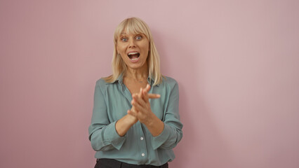 Middle-aged woman clapping enthusiastically against an isolated pink background