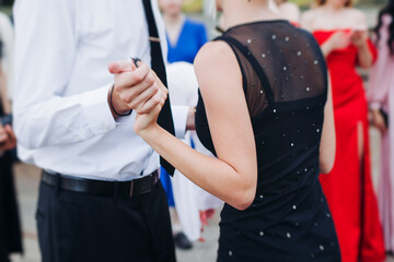 High school graduates dancing on prom, waltz and classical ball slow dance in dresses and suits on...