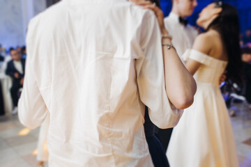 High school graduates dancing on prom, waltz and classical ball slow dance in dresses and suits on...