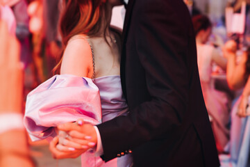 High school graduates dancing on prom, waltz and classical ball slow dance in dresses and suits on...