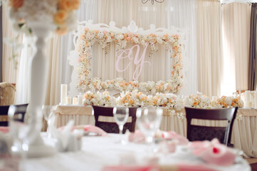 Wedding reception with floral backdrop, romantic candles, and elegant table decor.