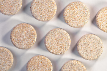 A pile of medical pills on a white table close-up
