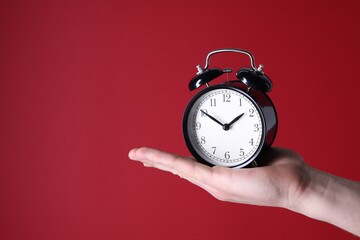 Man with alarm clock on red background, closeup. Space for text