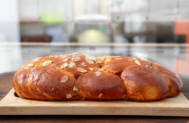 Easter sweet bread, homemade tsoureki braid on a wooden board, closeup