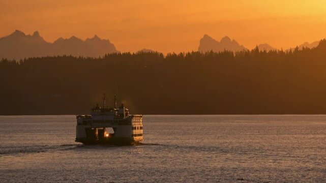 Washington state ferry at sea in the Puget sound with the Cascade mountains in the background.