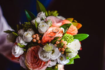 Engagement ring on bridal bouquet with roses, lisianthus, and hypericum berries