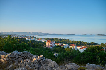 Nestled along the tranquil coastline, a charming village emerges as the sun rises, casting golden...