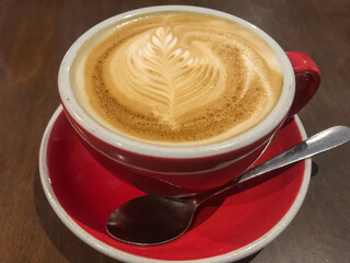 Closeup Of A Foam Design On A Red Cup Of Cappuccino With A Spoon