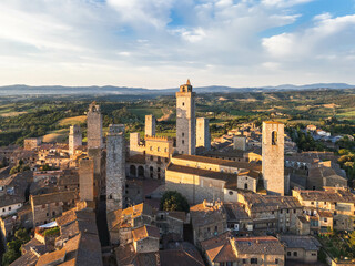 Naklejka premium Aerial view of San Gimignano medieval town towers skyline and countryside landscape on sunrise. Tuscany, Italy.
