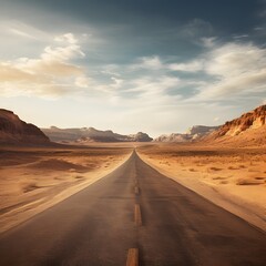 A long road in the desert with a few clouds in the sky