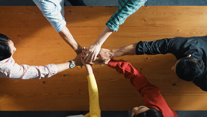 Close up of happy start up business people hand putting hands together at meeting and clapping hand to celebrate collaboration and increasing sales or encourage teamwork and togetherness. Convocation.