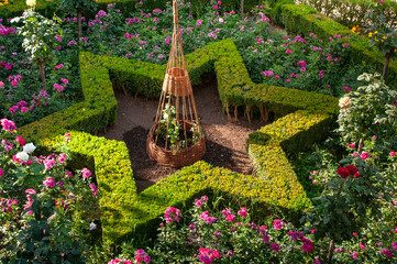 Ornately landscaped gardens inside the Alhambra palace with shrubbery carved into the shape of a...