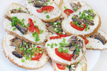 toasts with sprats and green onions on plate. Cold appetizers. Sandwiches