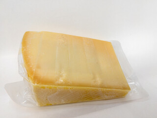 Slice of parmesan cheese vacuum sealed in plastic bag on white back ground