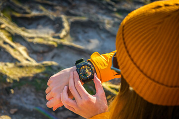 Over the shoulder view of Female Checking Current Altitudeon Casio Wrist Watch While Exploring a...